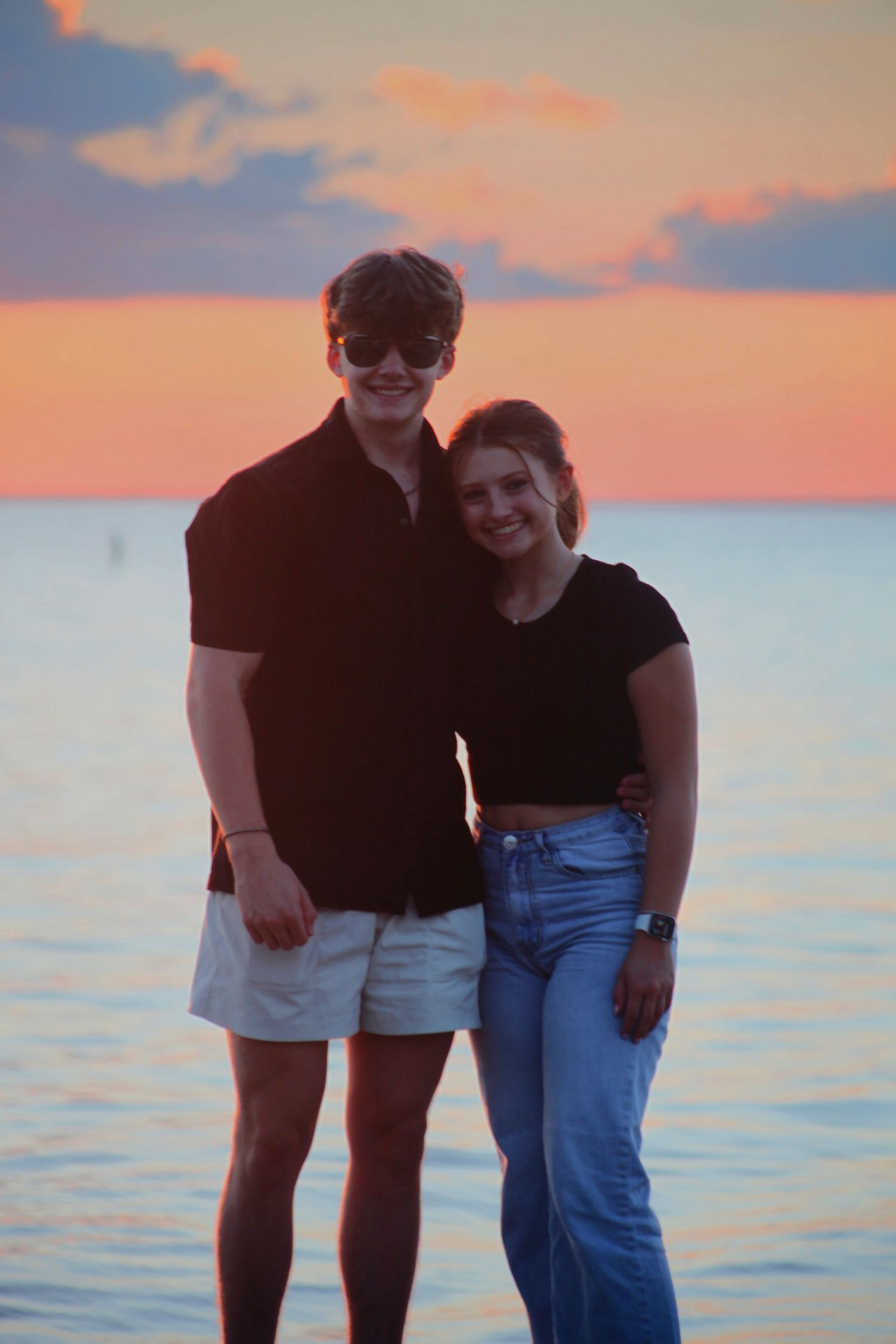 A couple standing in front of the sunset