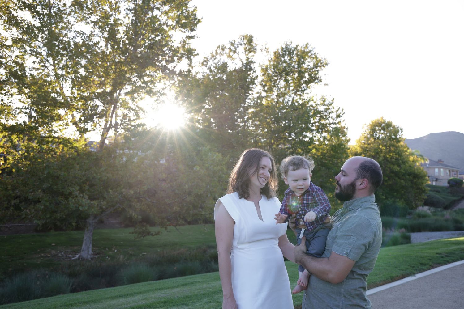 Group enjoying a sunset moment in a grassy park with mountains visible in the distance.