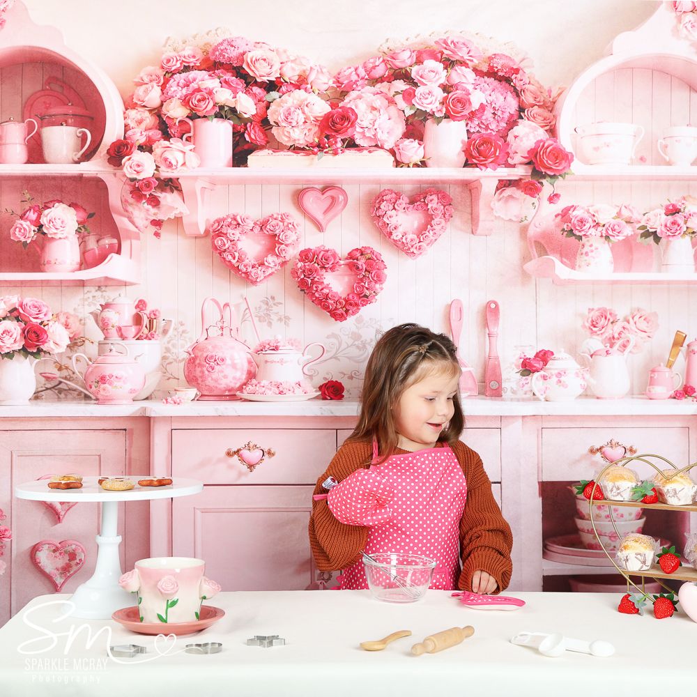 Pink Valentine's day themed tea party setup with hearts and floral decorations on white shelving display.