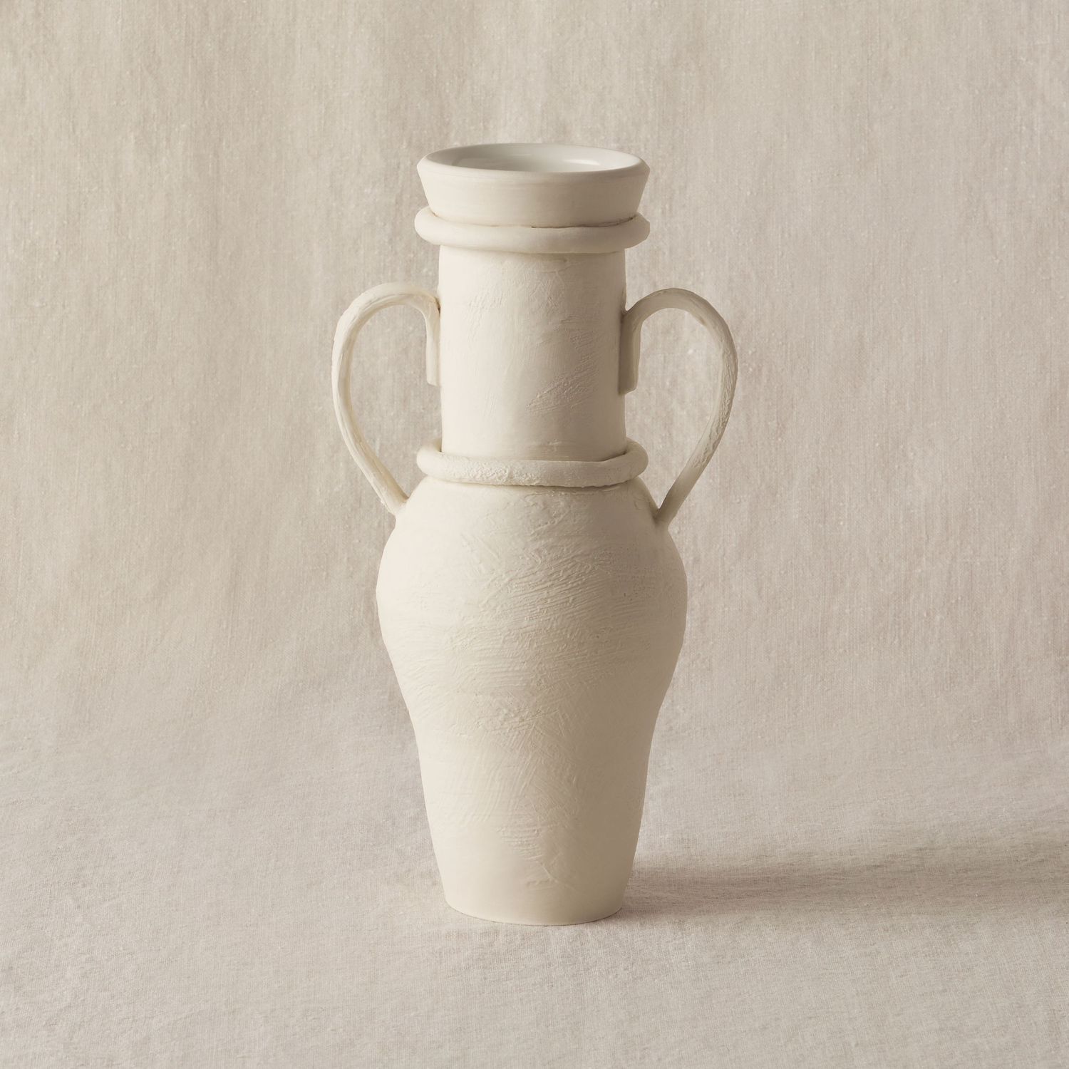 antique cream textured ceramic vase on linen background