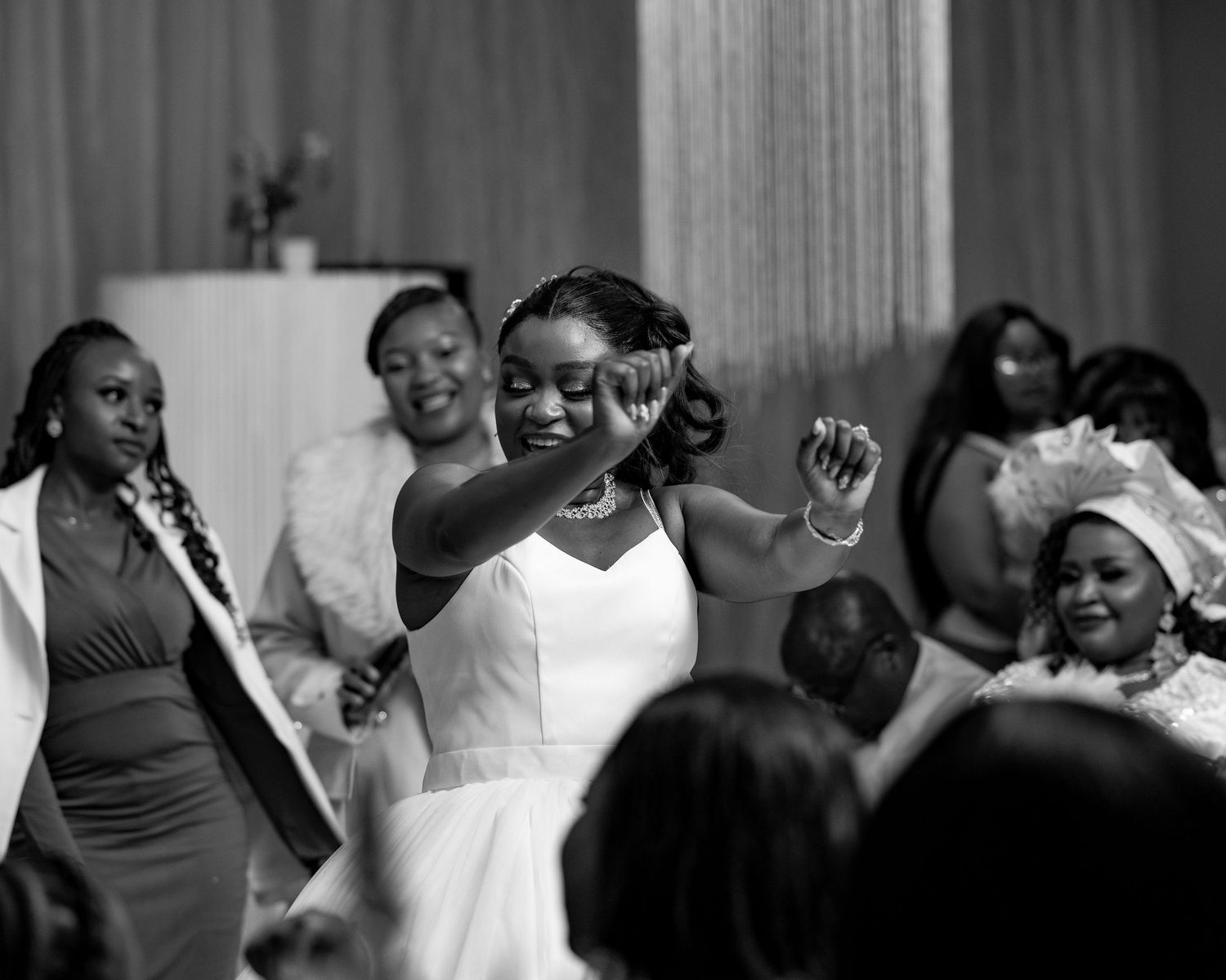 Black and white photo of wedding celebration with guests dancing.