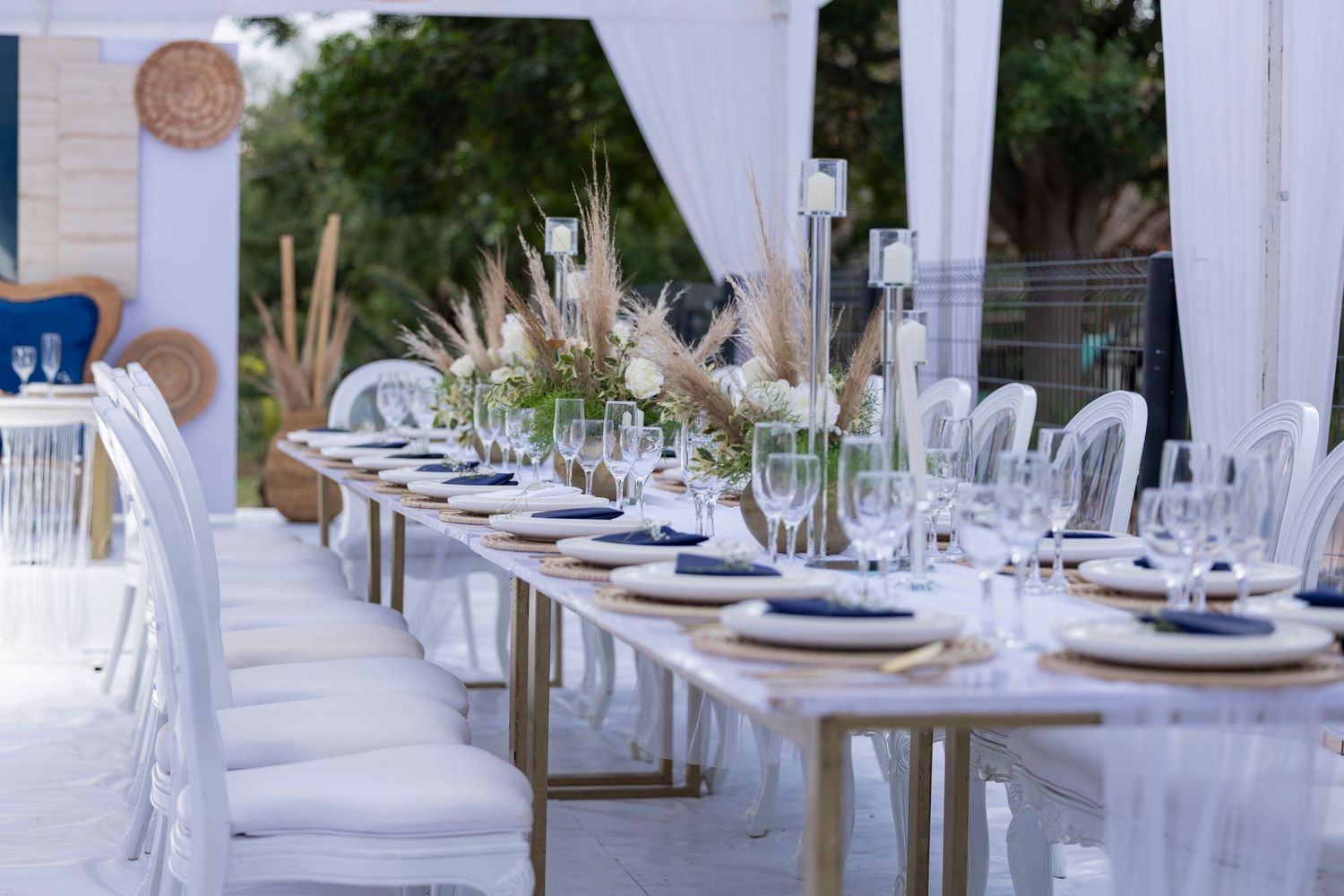 Elegant outdoor wedding reception setup with white tables and place settings.