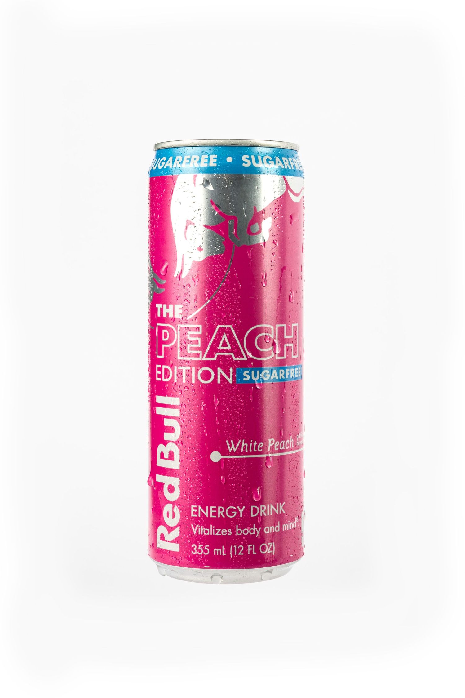 Can of Red Bull Peach Edition Sugar-Free energy drink with water droplets on white background.