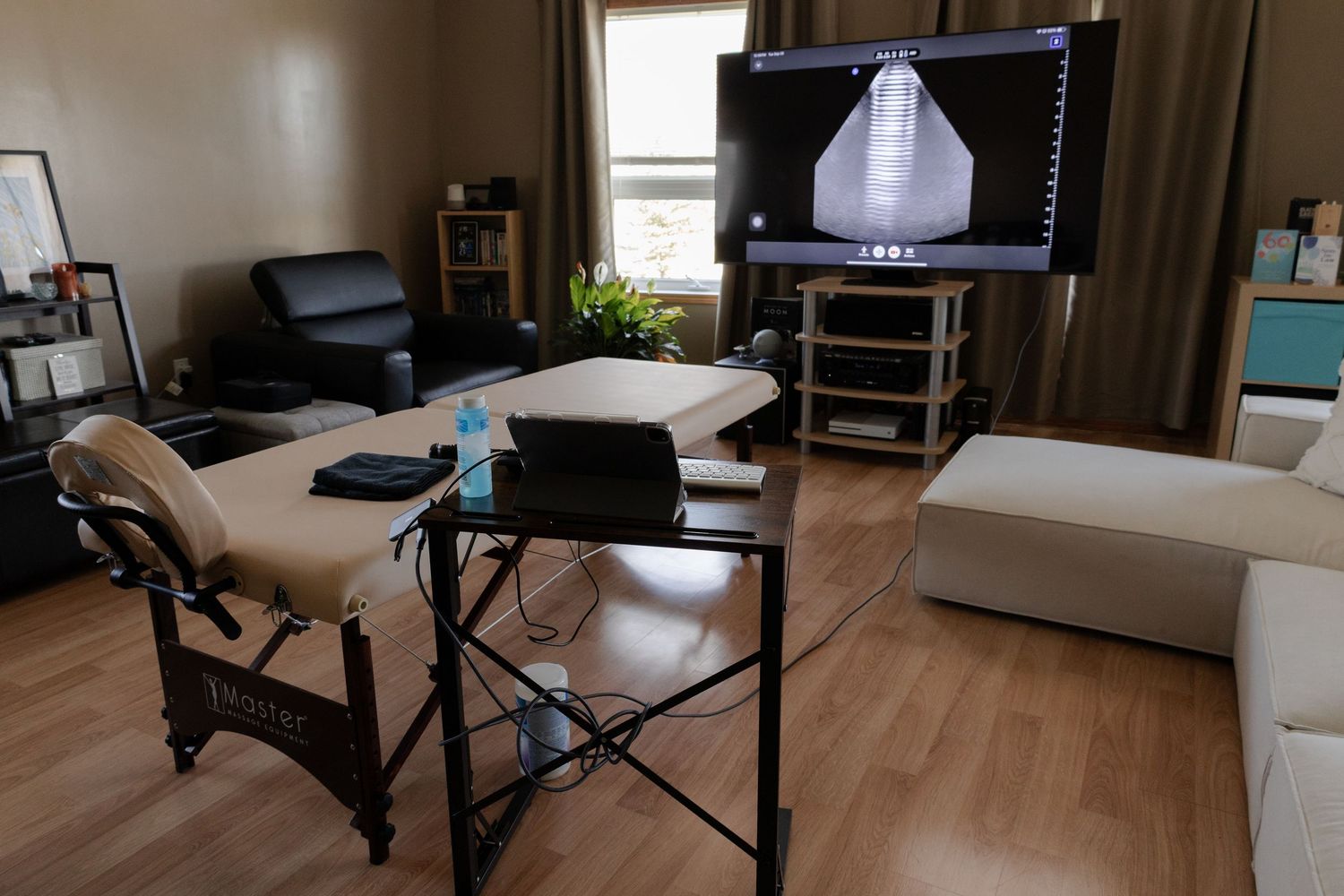 Welcoming ultrasound studio with padded table, TV monitor showing fetal scan, and relaxing decor in Winnipeg