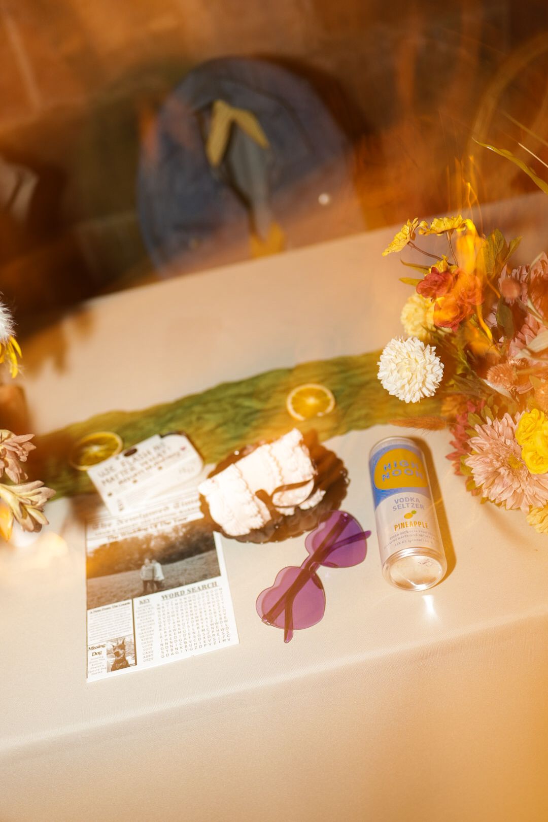 Wedding reception details with sunglasses, drinks and decorative items on a table.
