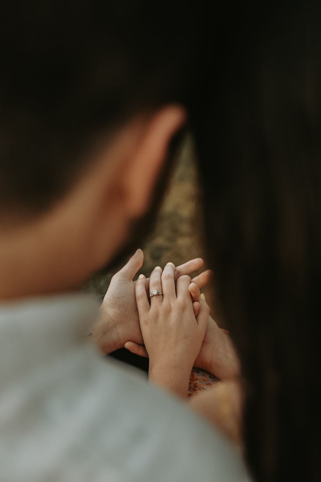 Close-up of hands tenderly touching during an intimate moment.