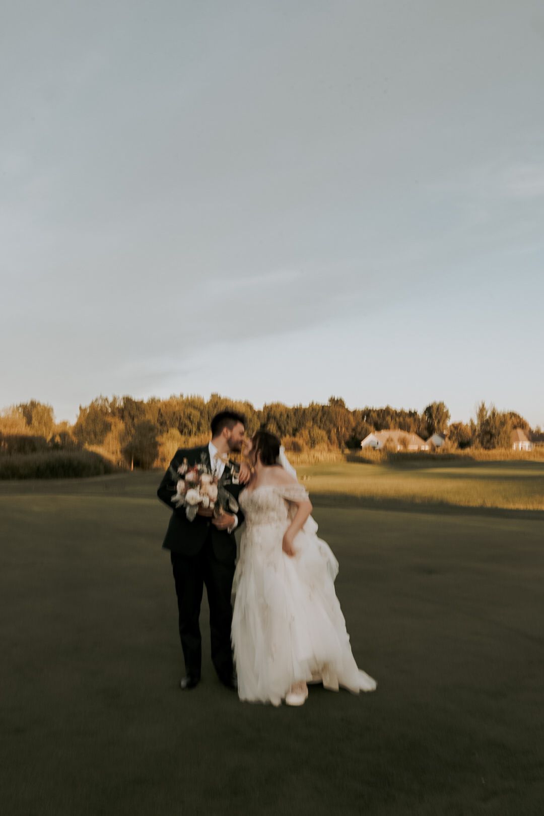 Michigan wedding photographer capturing a candid bride and groom outdoors in natural light