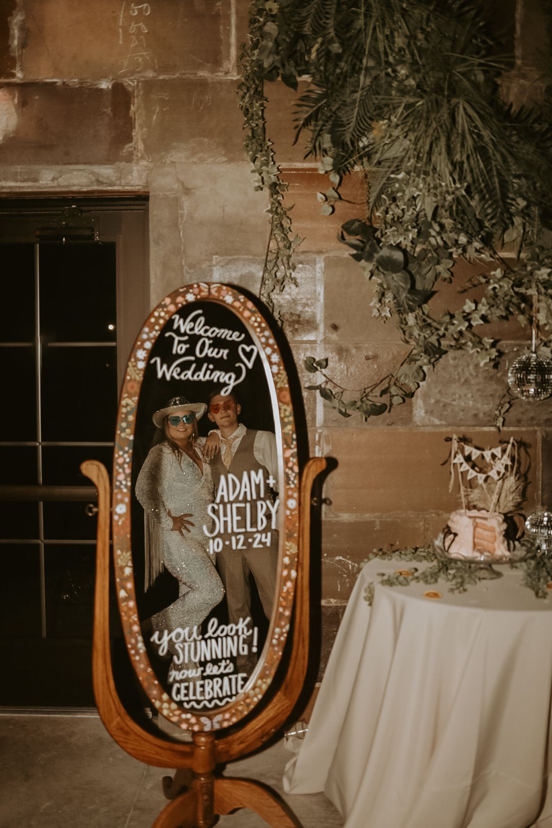 Illuminated horseshoe-shaped wedding welcome sign with handwritten text and decorative lights.