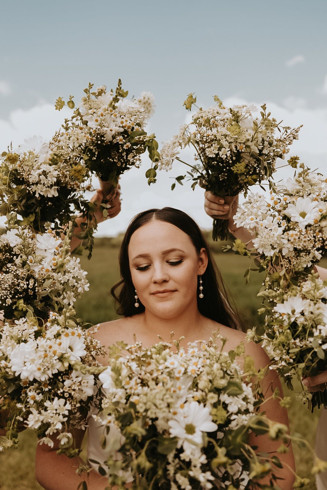 Delicate white spring blossoms frame close-up portrait in outdoor setting.
