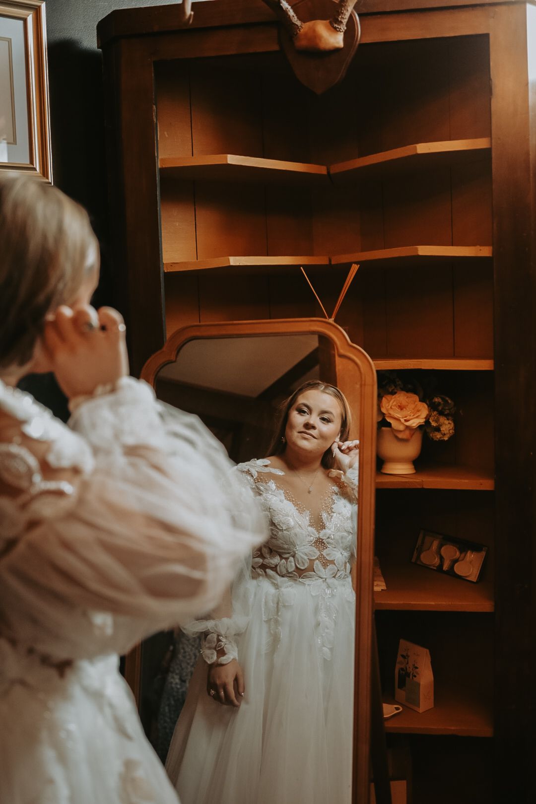 A romantic bridal preparation scene with soft lighting and wooden built-in shelving.