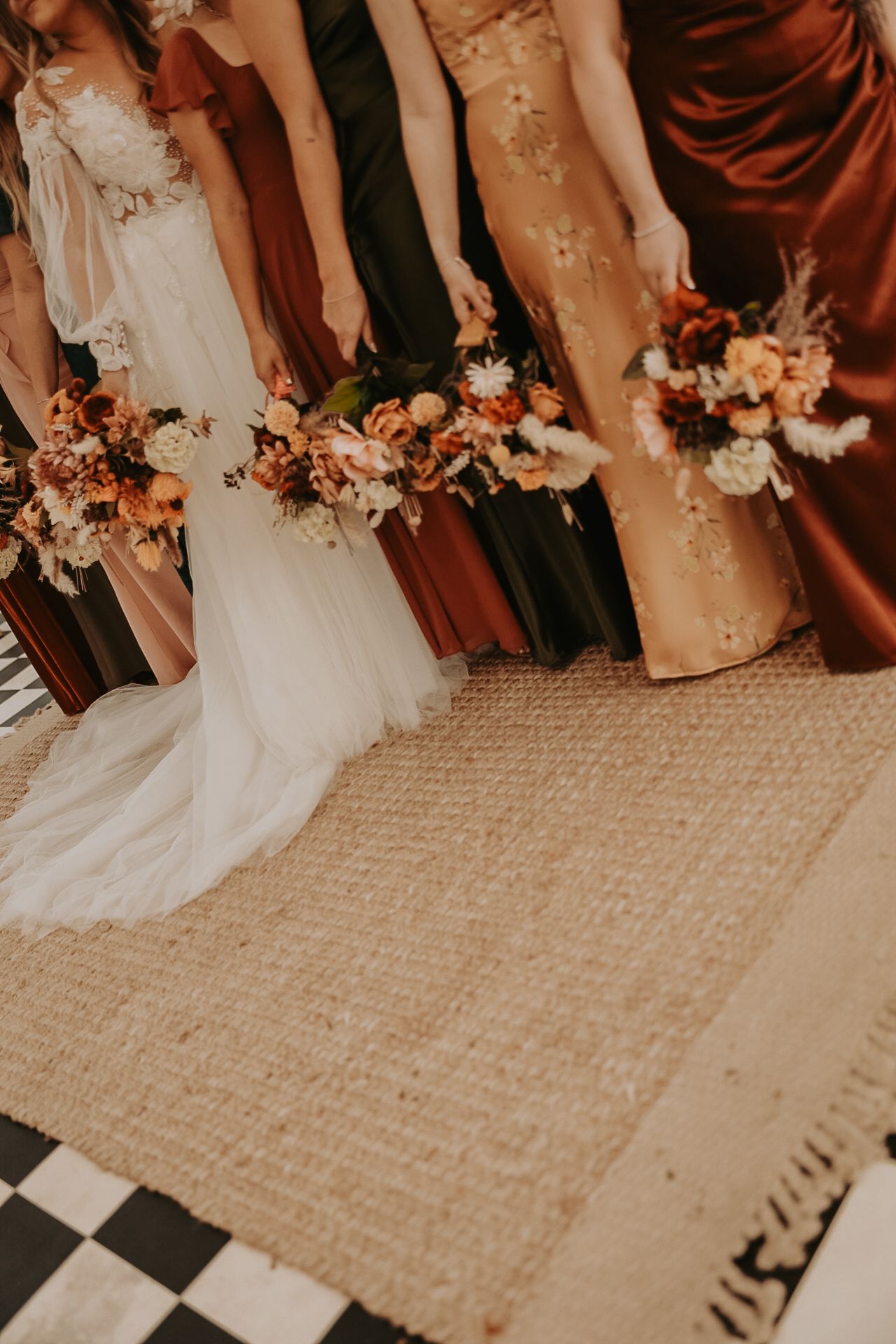 Wedding party members' feet and dresses shown on a checkered floor.