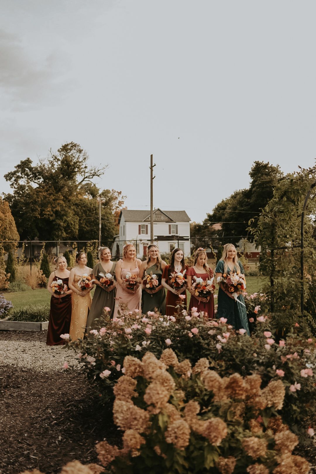 Wedding guests seated outdoors with beautiful autumn flowers in foreground.