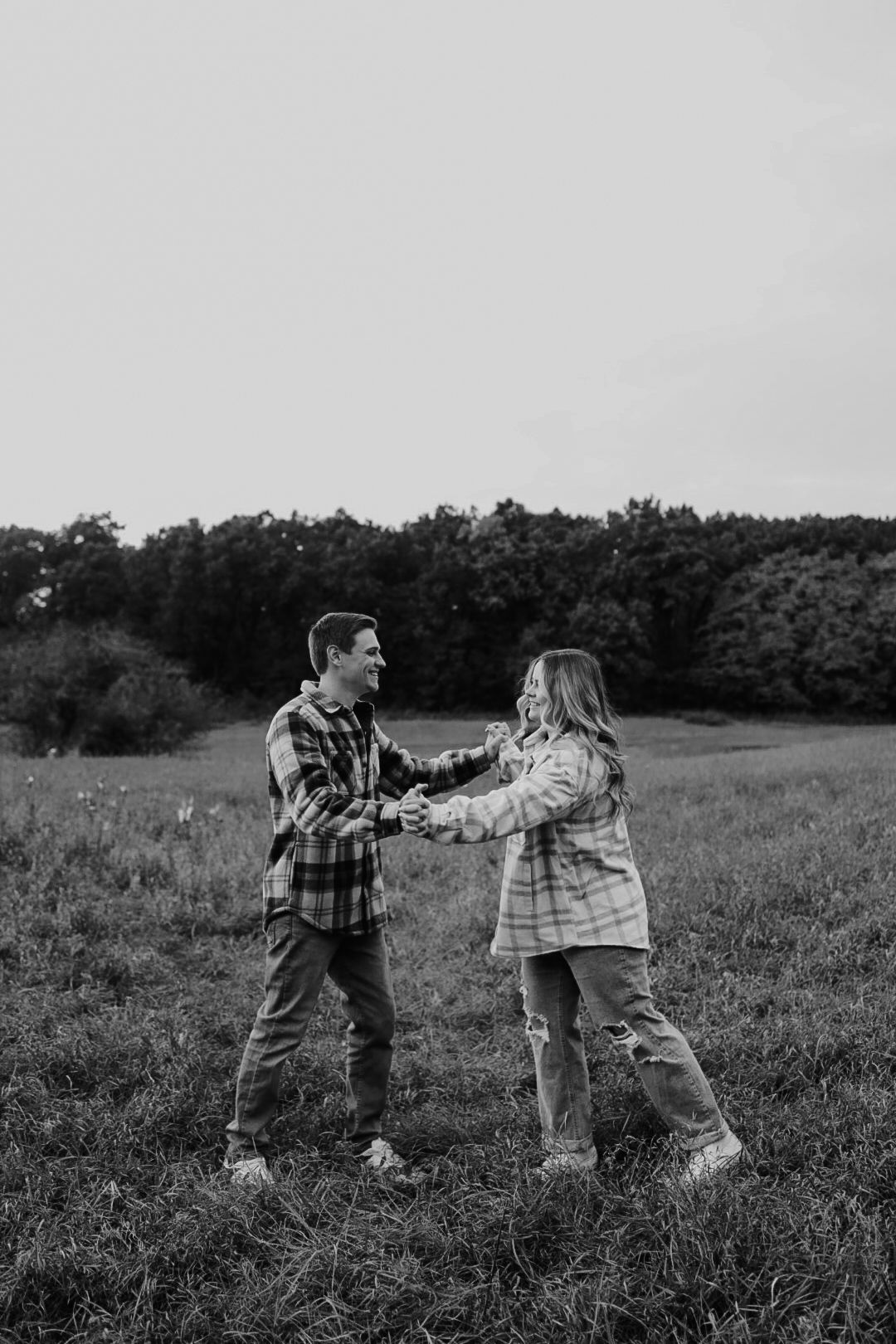 Playful moment in autumn field with plaid shirts and fall foliage.