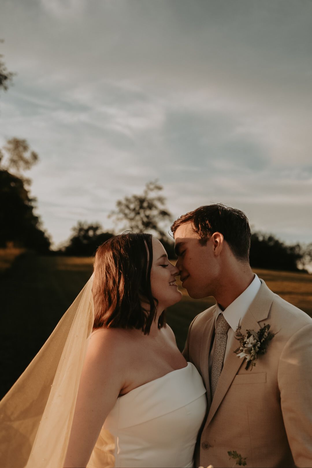 Intimate wedding portrait captured during sunset with warm autumn tones.