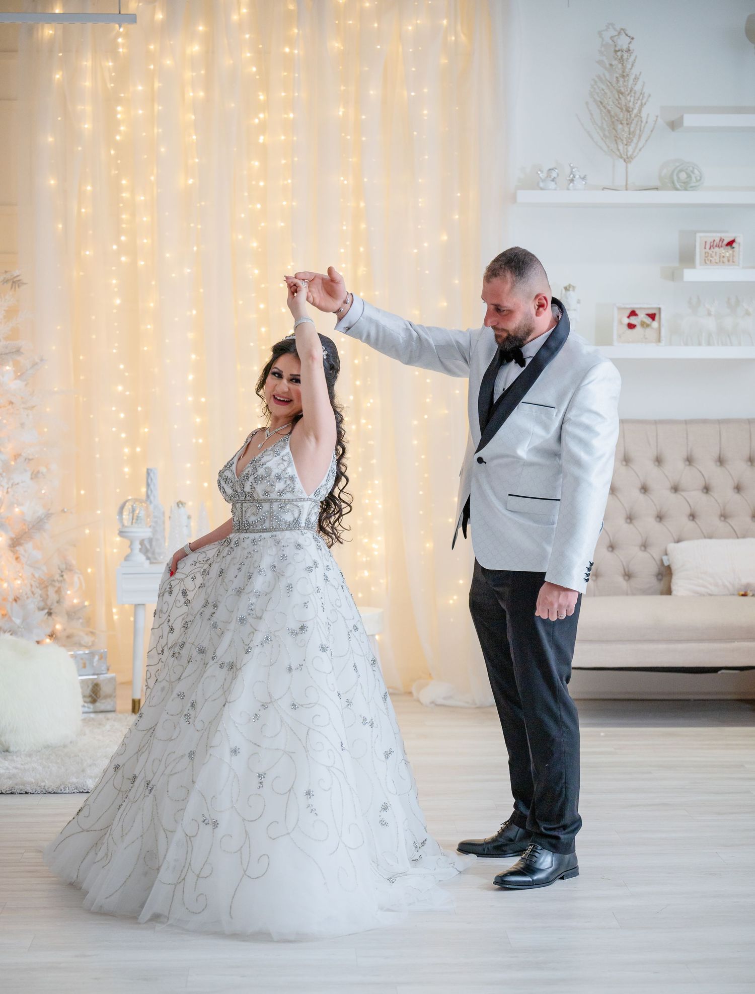 A couple performs a dance move against a backdrop of twinkling fairy lights.