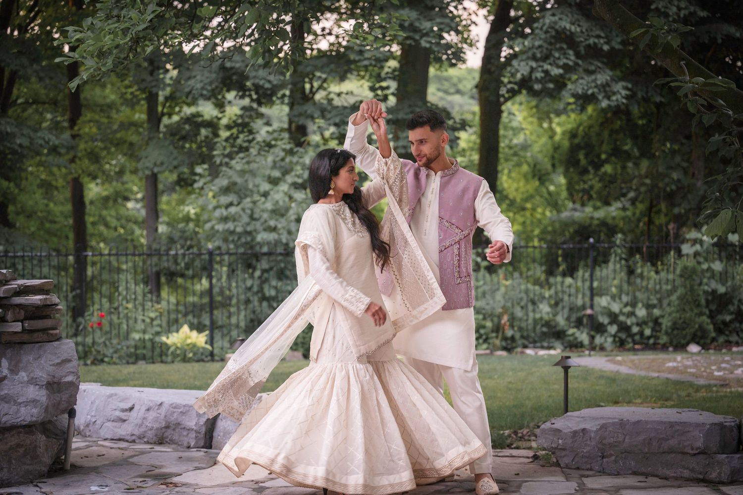 Elegant outdoor photography session with flowing pink dresses in a lush garden setting.