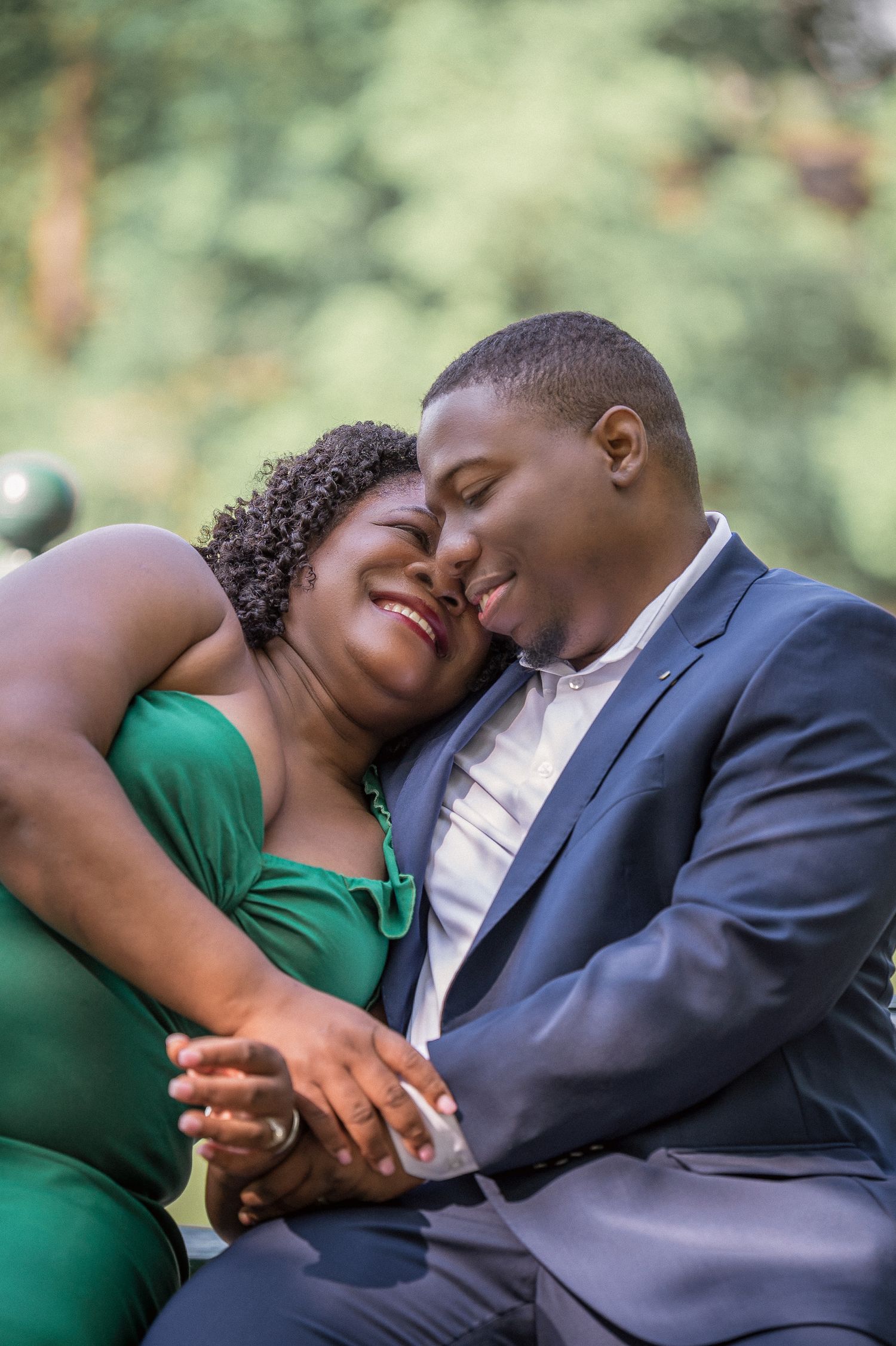Couple in formal attire sharing intimate moments during an outdoor engagement photoshoot.