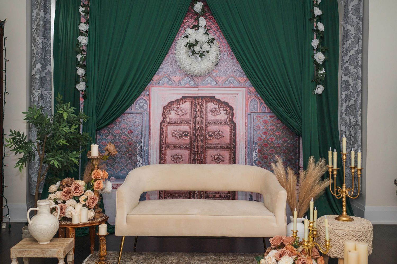 Elegant wedding stage setup with emerald green curtains and classic decor elements.
