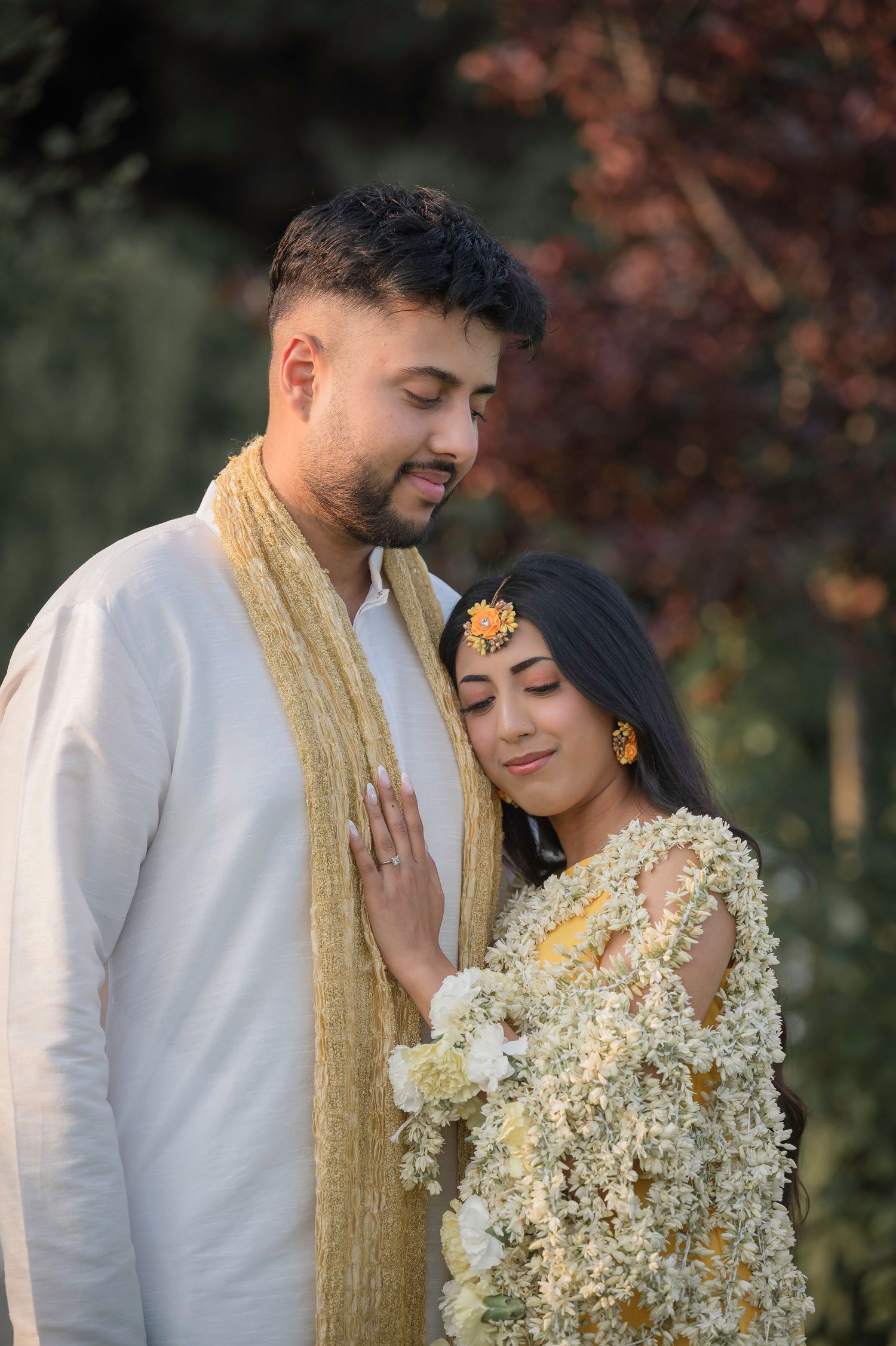 Romantic couple portrait with white and gold attire adorned with delicate baby's breath flowers.