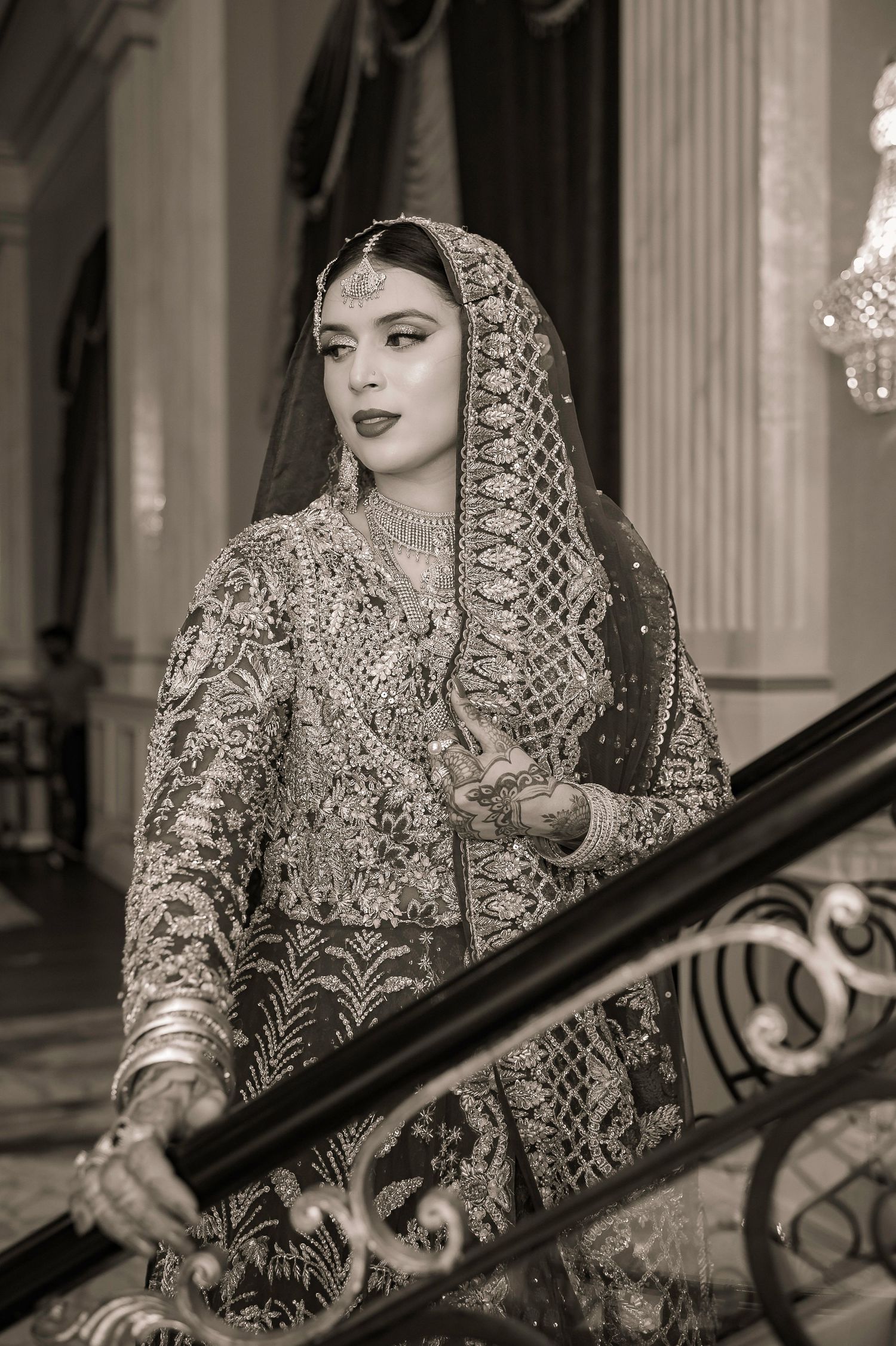 Traditional bridal portrait on elegant staircase in black and white.