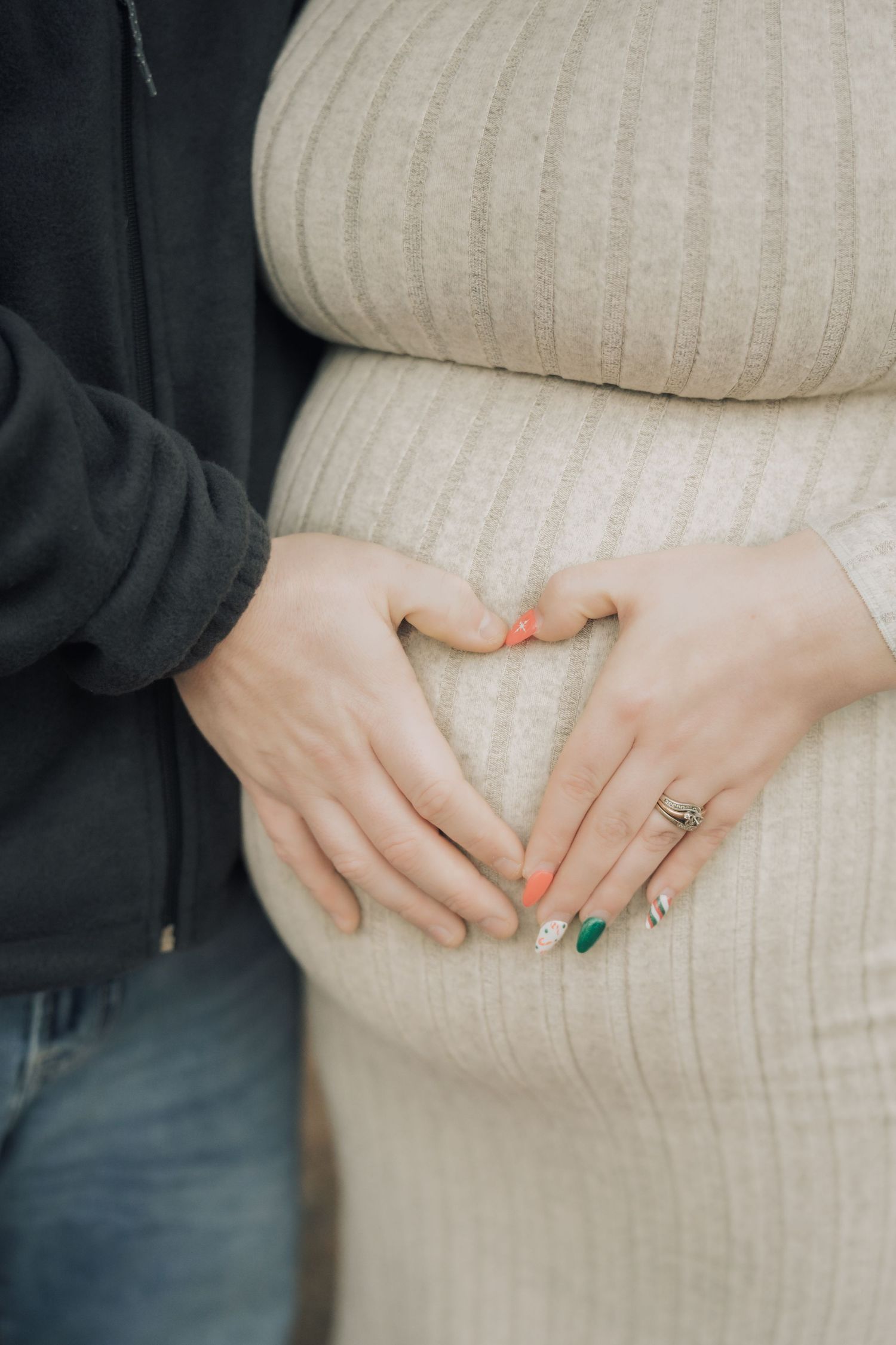 A series of hands resting on a cream ribbed sweater showing a pregnancy progression timeline.