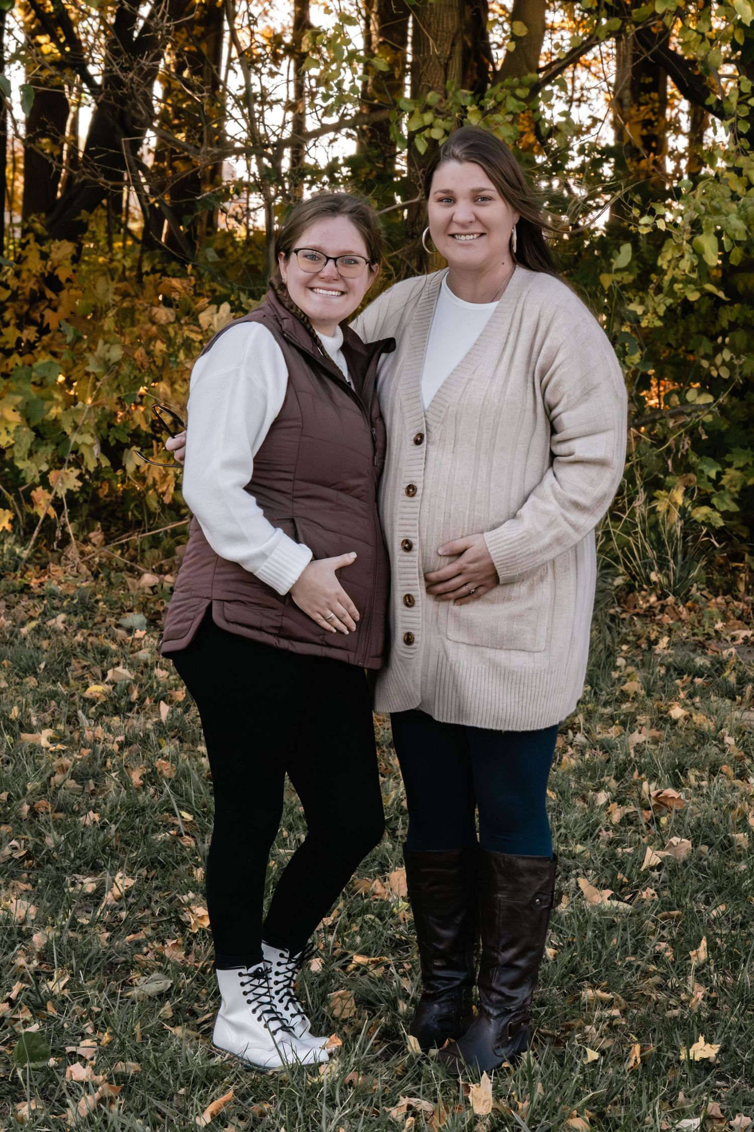 Two people pose together for casual portraits in an autumn forest setting.