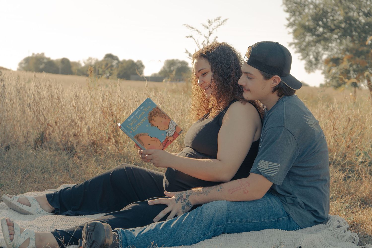 Couple relaxing together in a golden wheat field at sunset.