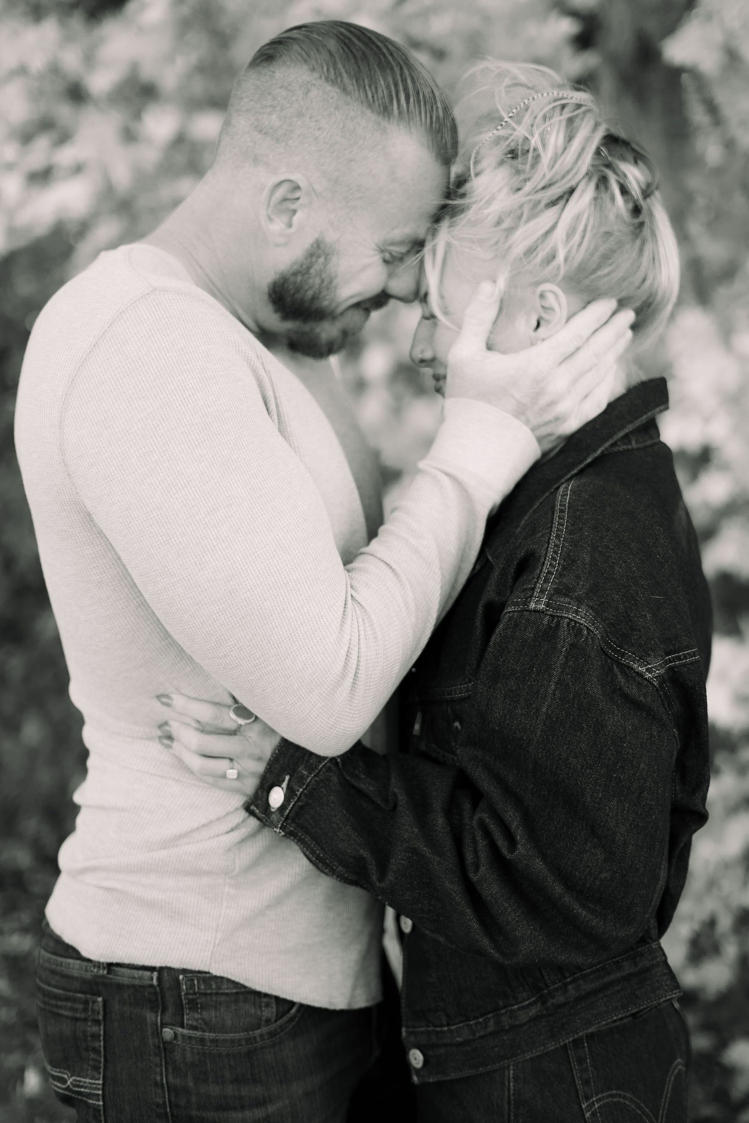 Black and white photo series showing a couple sharing intimate moments against a blurred background.