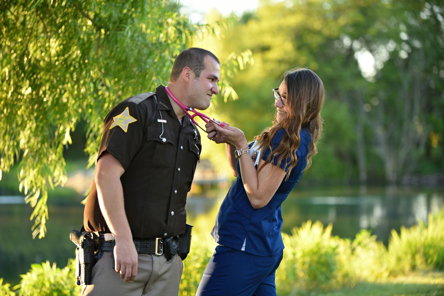 Candid moment of a couple in uniform and casual wear playing around near a lake.