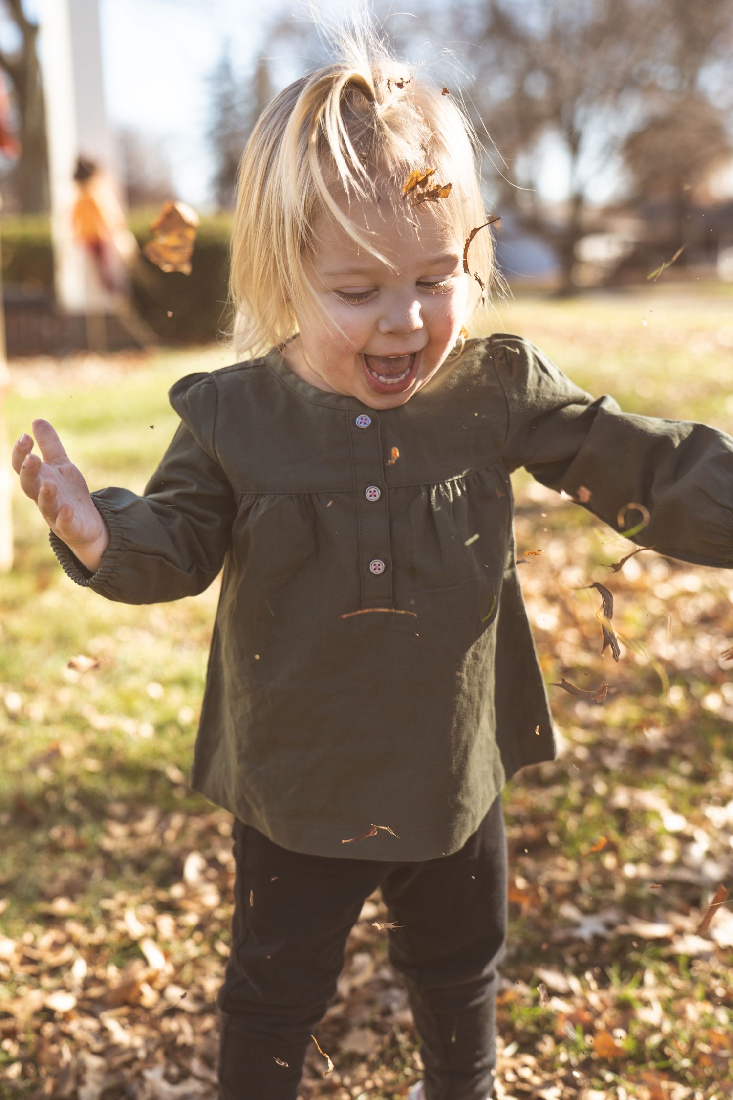 Playful autumn scene with falling leaves and joyful movements outdoors.