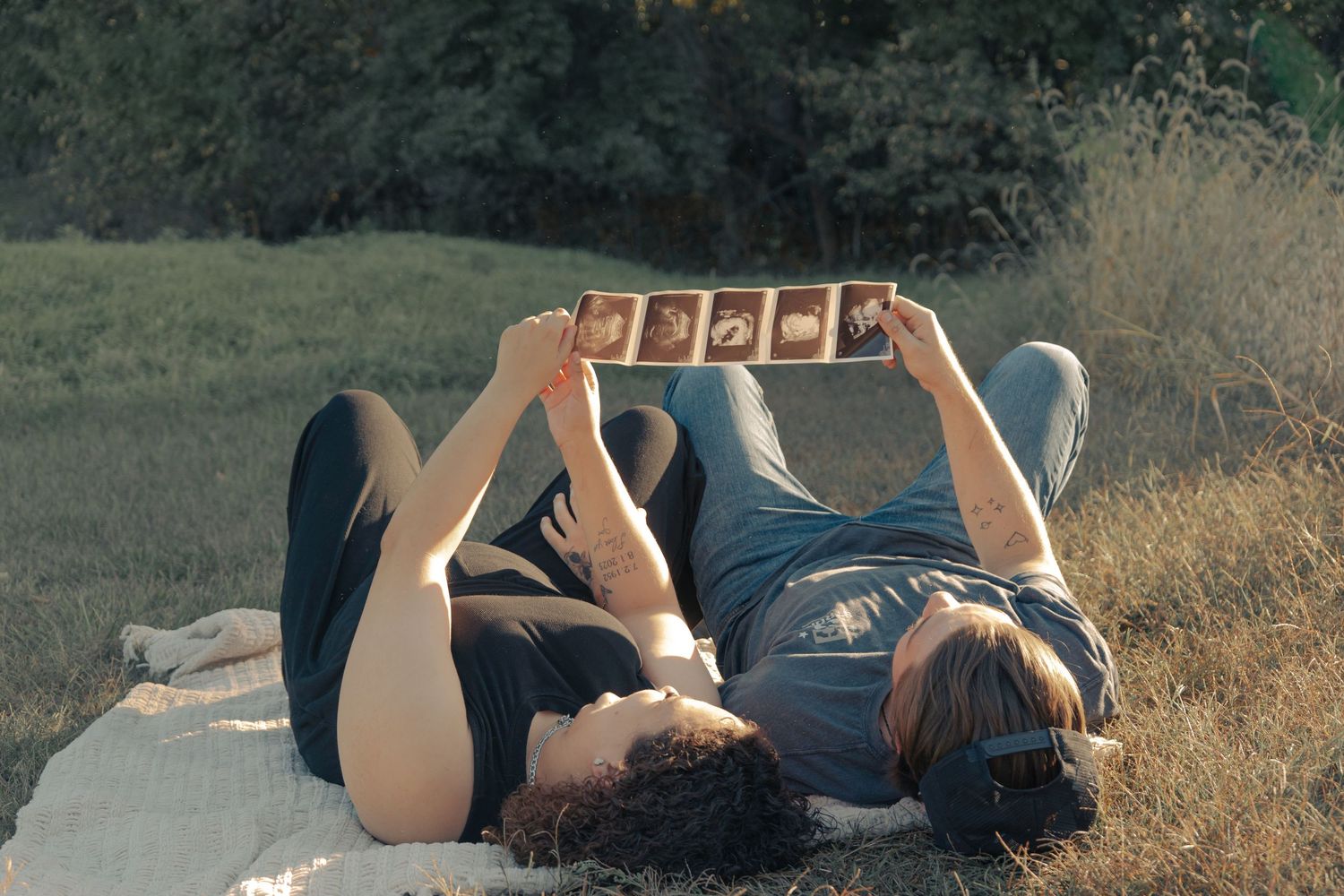 Candid shots of a couple lying in tall grass during golden hour.