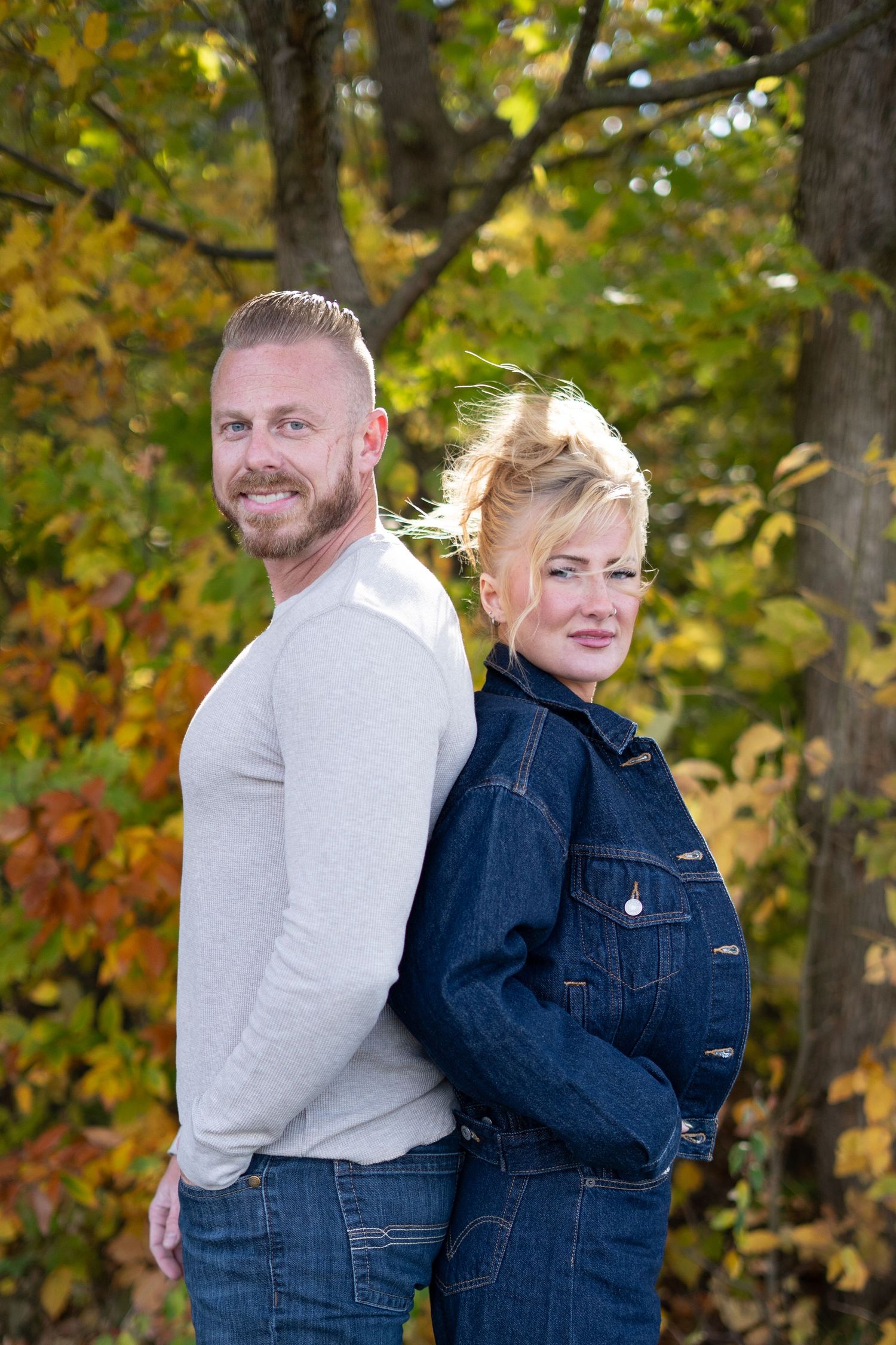 Romantic photoshoot sequence in a park with vibrant fall colors in the background.