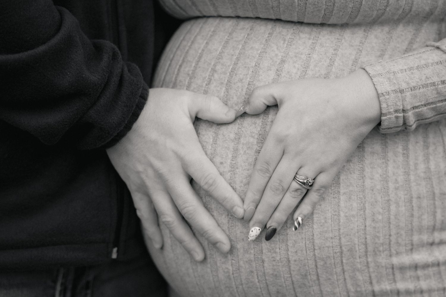 Close-up shots of hands tenderly placed on a maternity bump.