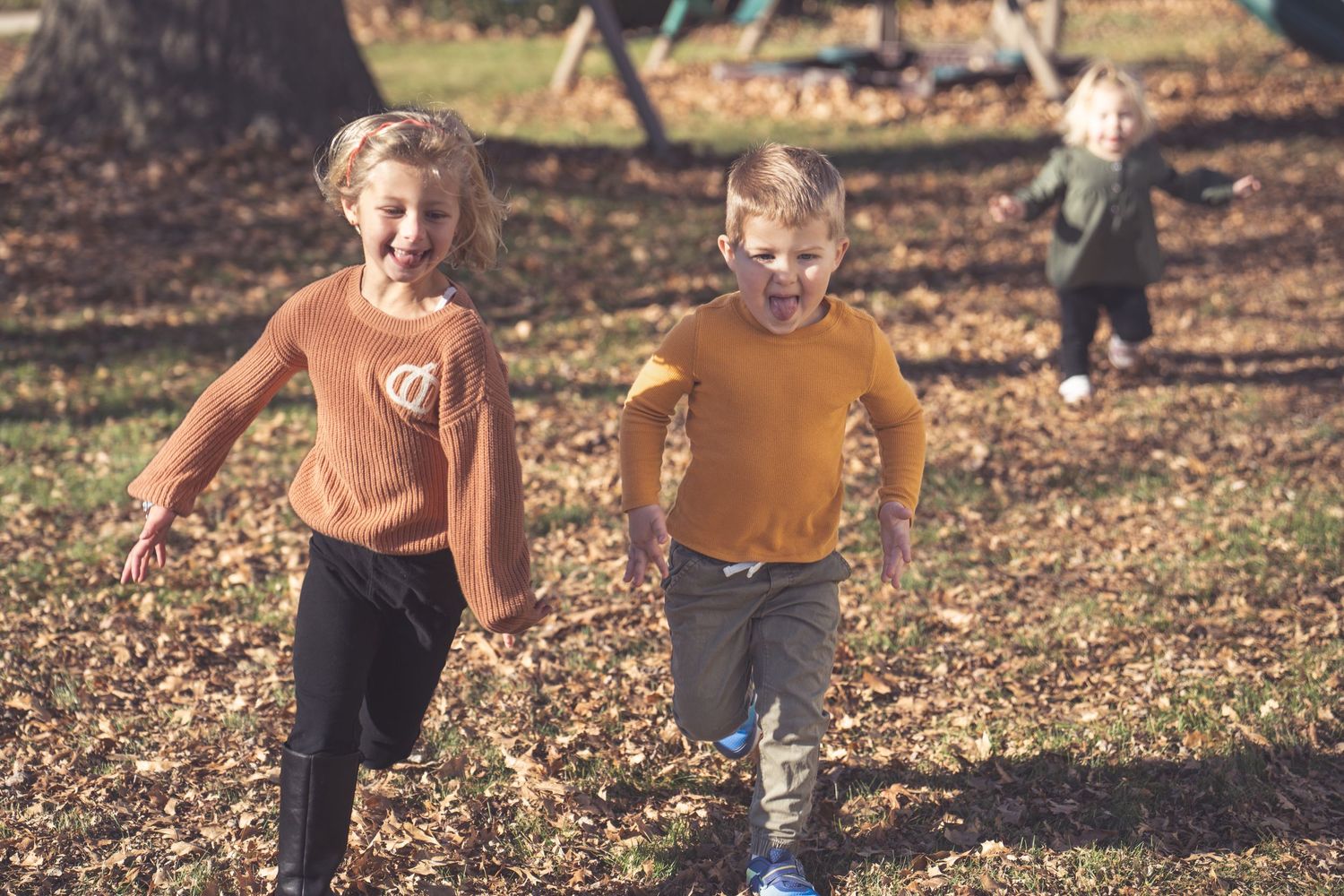 Active play scene with running and jumping in autumn leaves.