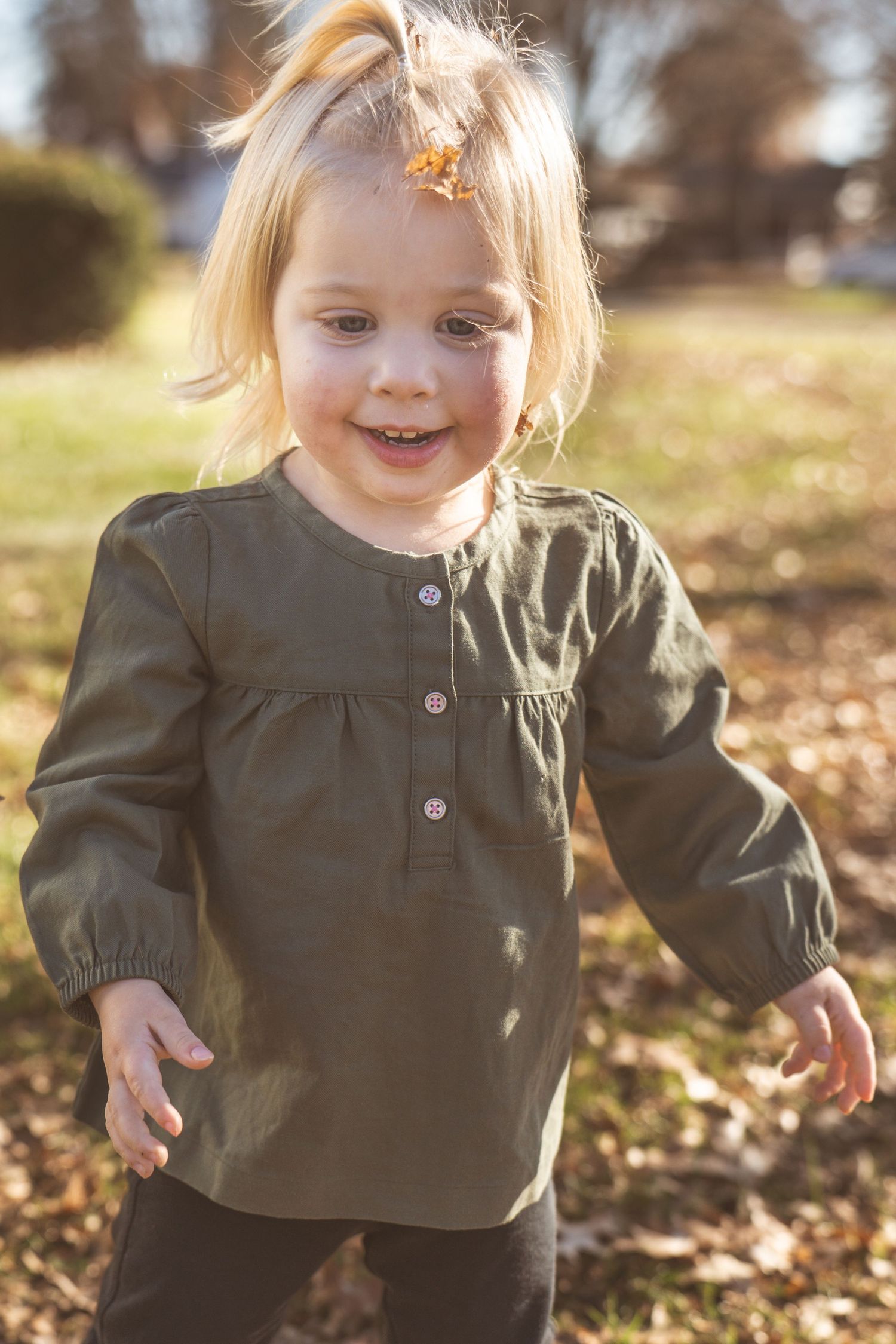 Candid outdoor portraits in an olive green top with natural sunlight.