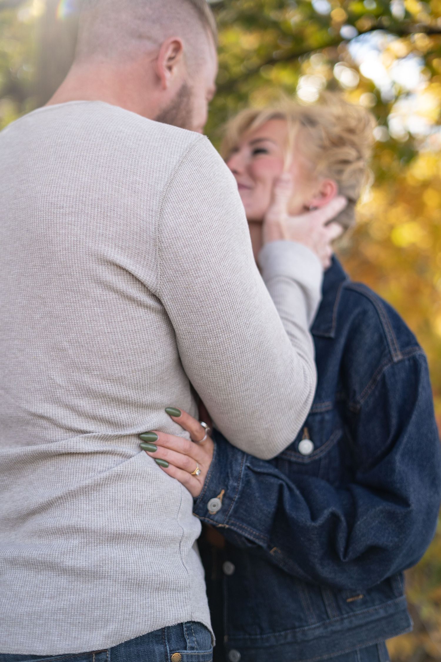 Intimate moment between couple wearing casual sweaters during golden hour.
