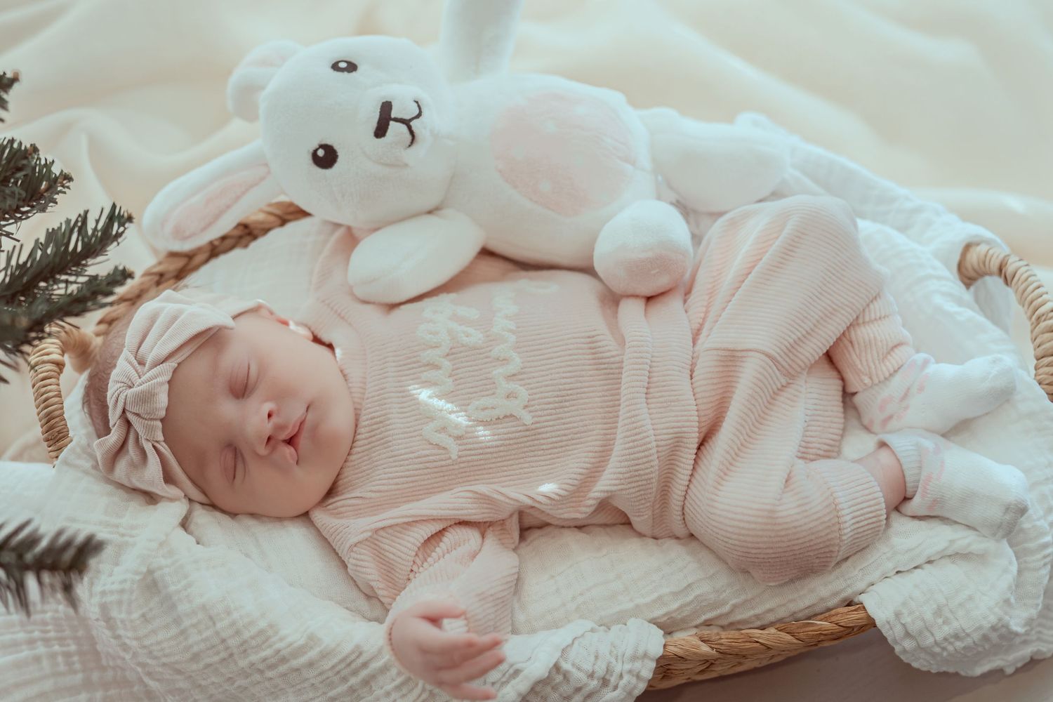 Adorable baby sleeping peacefully on soft white blanket in gentle natural light.