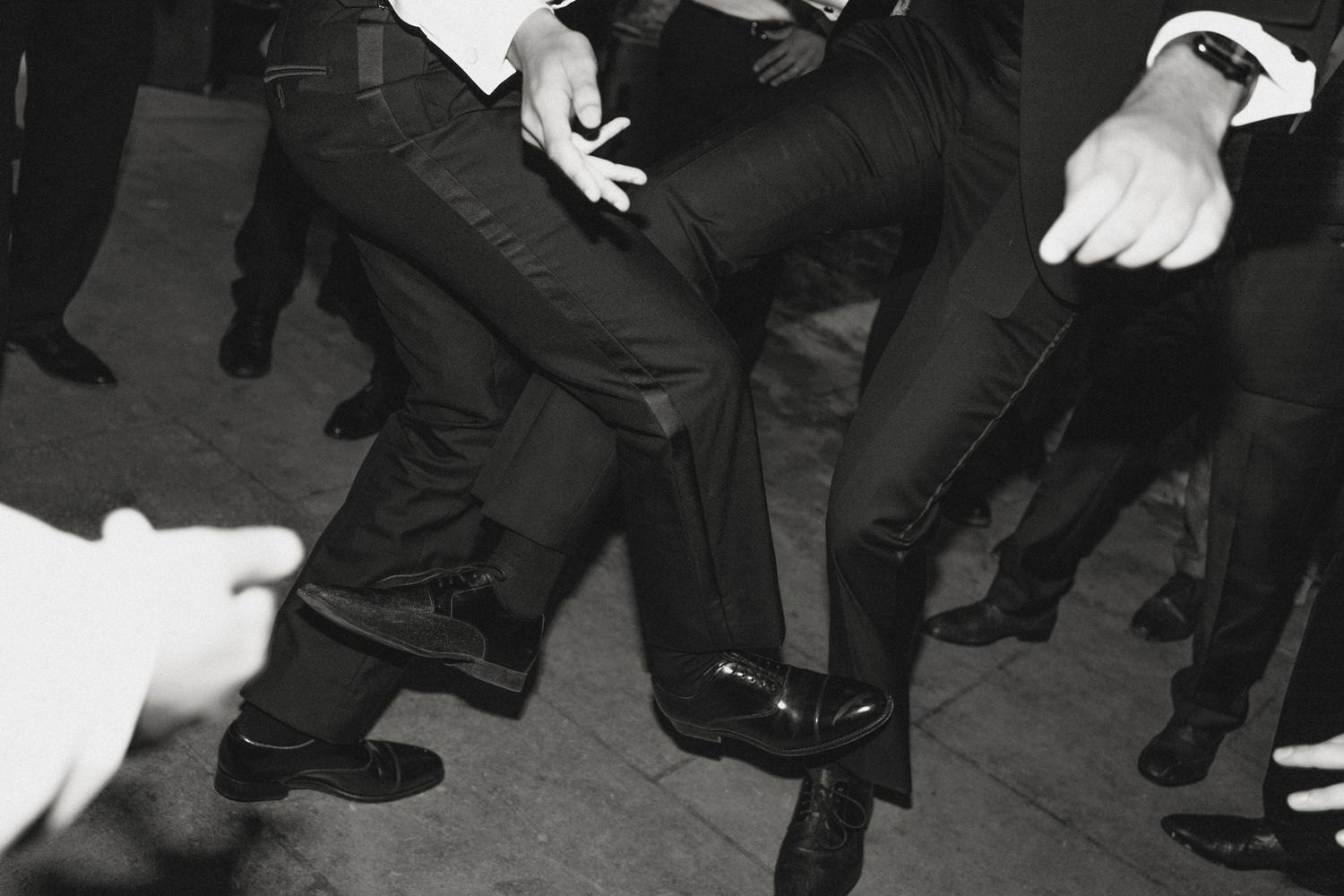 Black and white shot of people dancing at formal event.