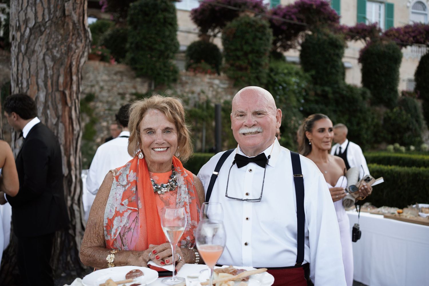 Guests enjoying dinner at an outdoor wedding reception.