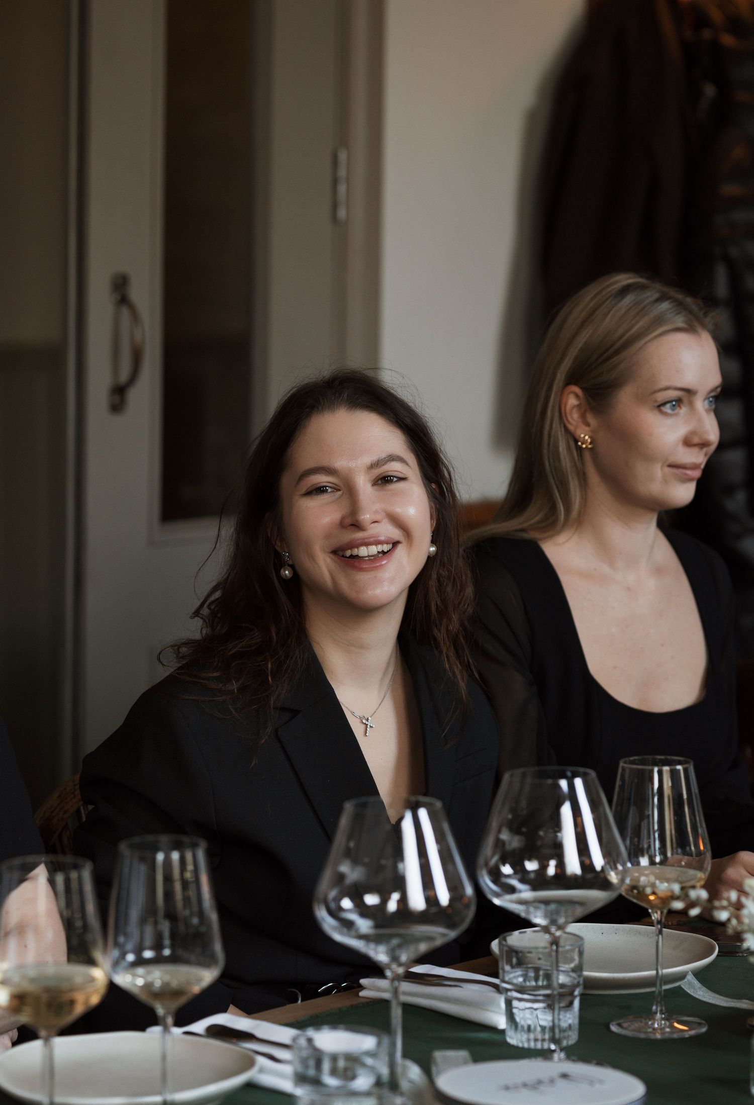 Two people enjoying wine and conversation at an elegant dining table.