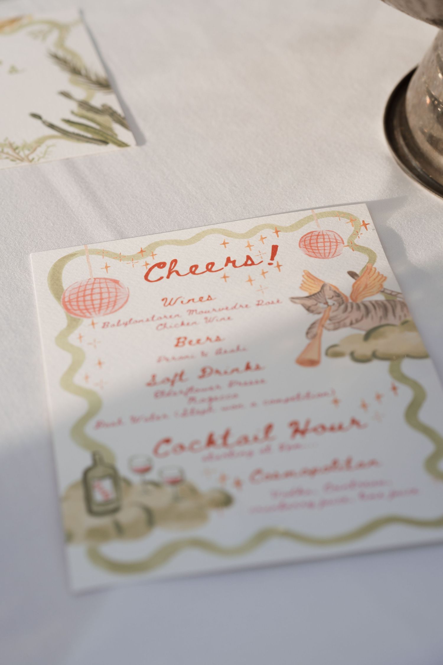 Whimsical illustrated menu card with 'Cheers!' text and decorative borders.