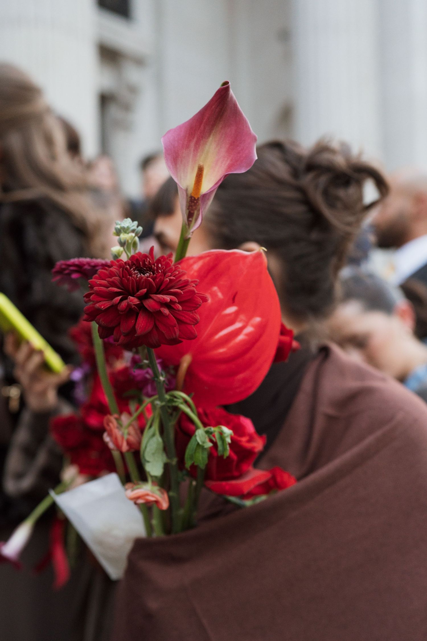 Deep red floral arrangements with dahlias and calla lilies create a romantic wedding atmosphere.