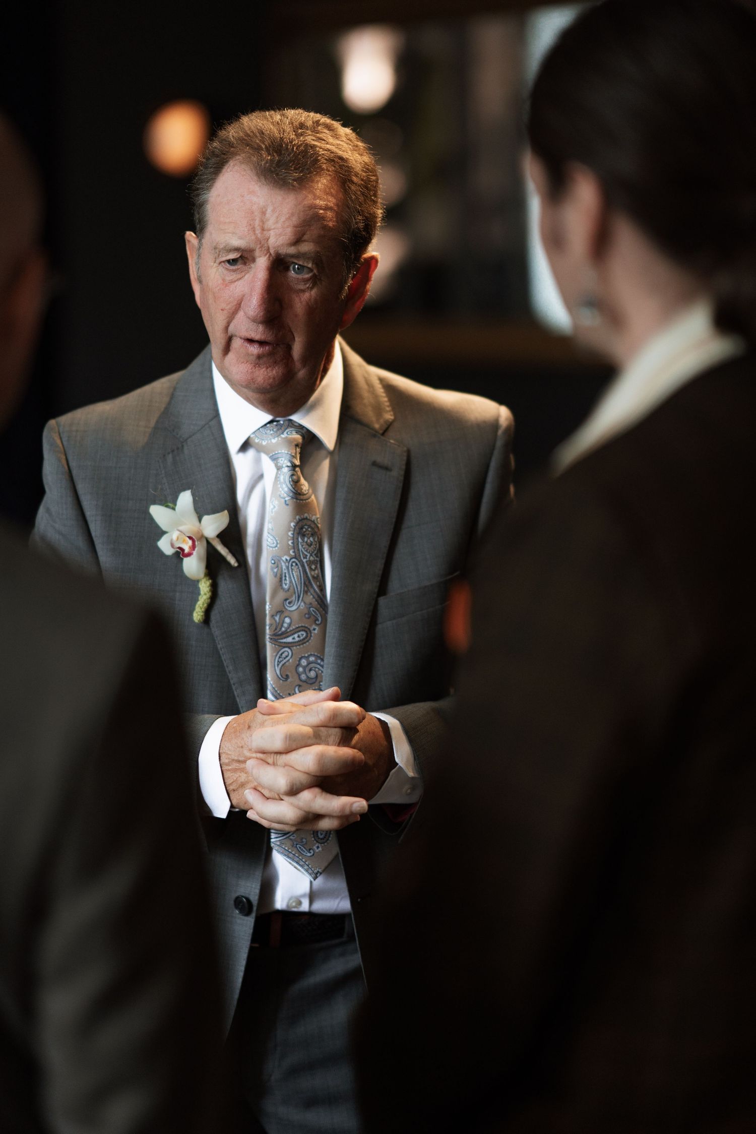Man in formal attire with boutonniere at formal event.