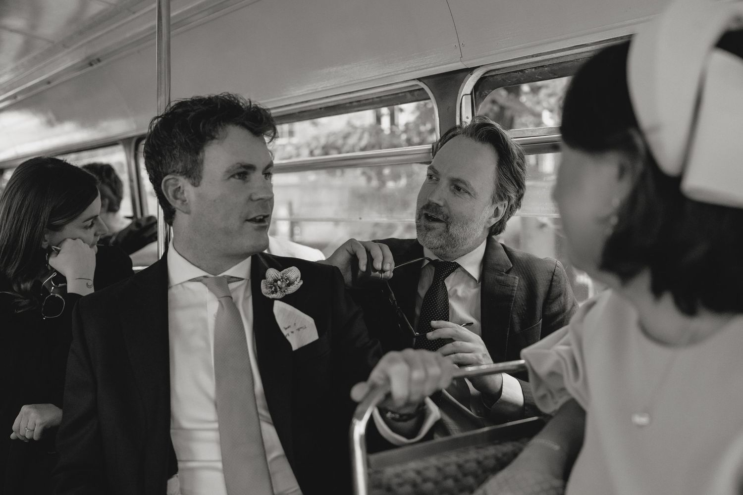 Wedding guests share laughter and joy during a candid moment at a reception.