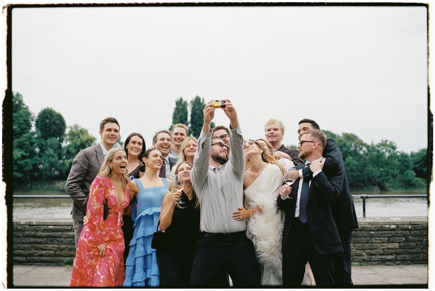 Wedding party gathered outdoors for group photos.
