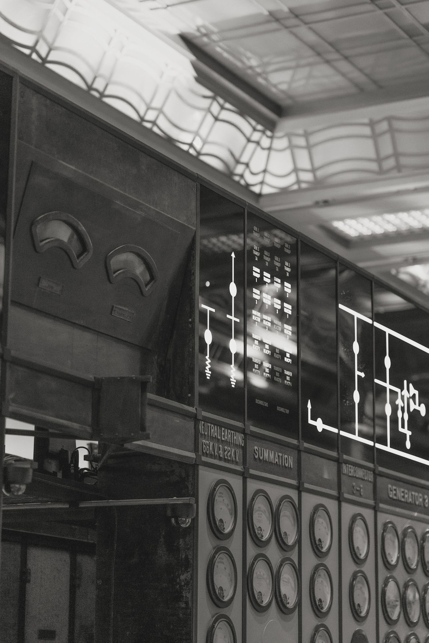 Industrial interior hallway with vintage mechanical control panels and gauges lining the walls.