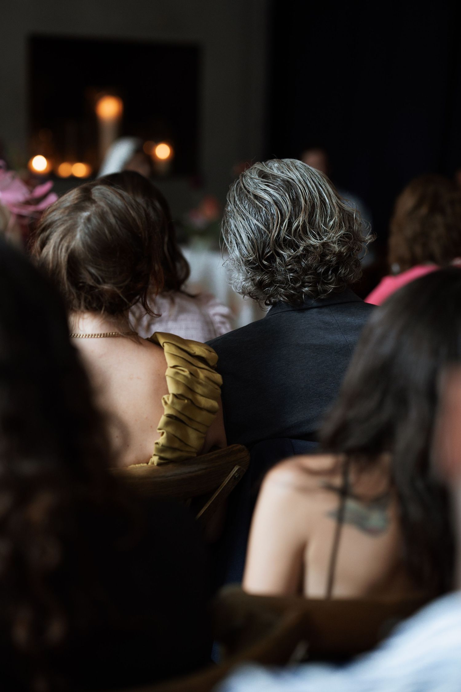 Dark silhouettes of attendees in a dimly lit event space.