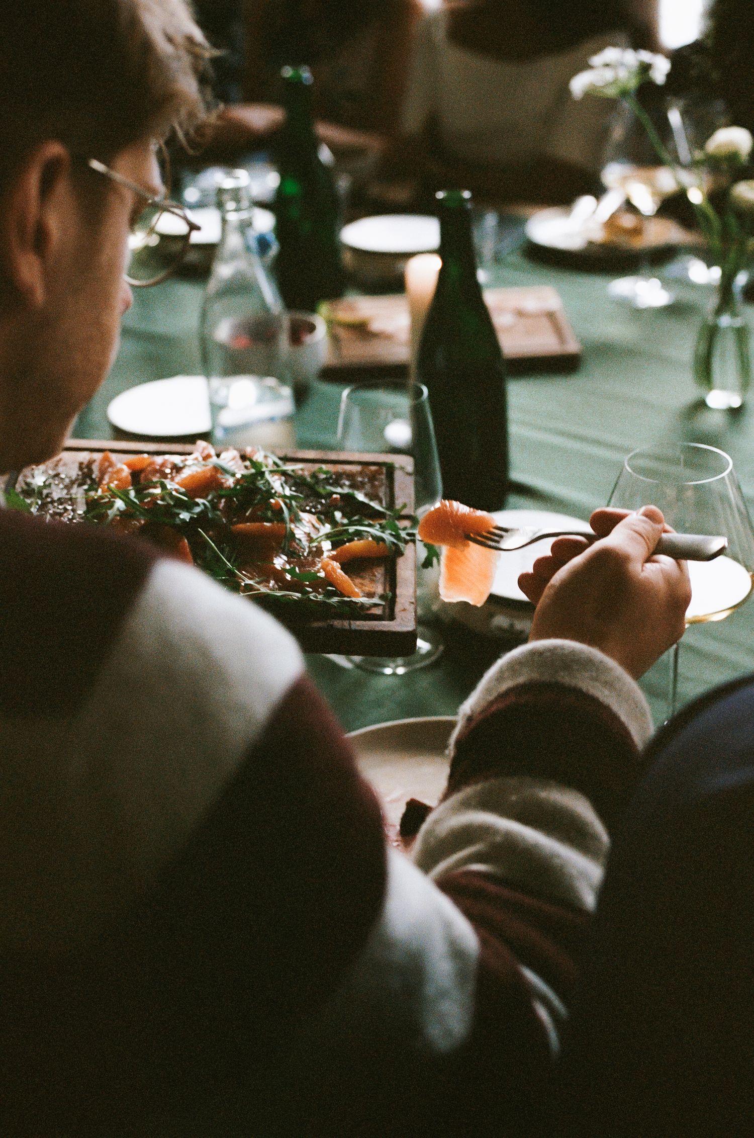 Silhouettes of people dining at an intimate restaurant setting.