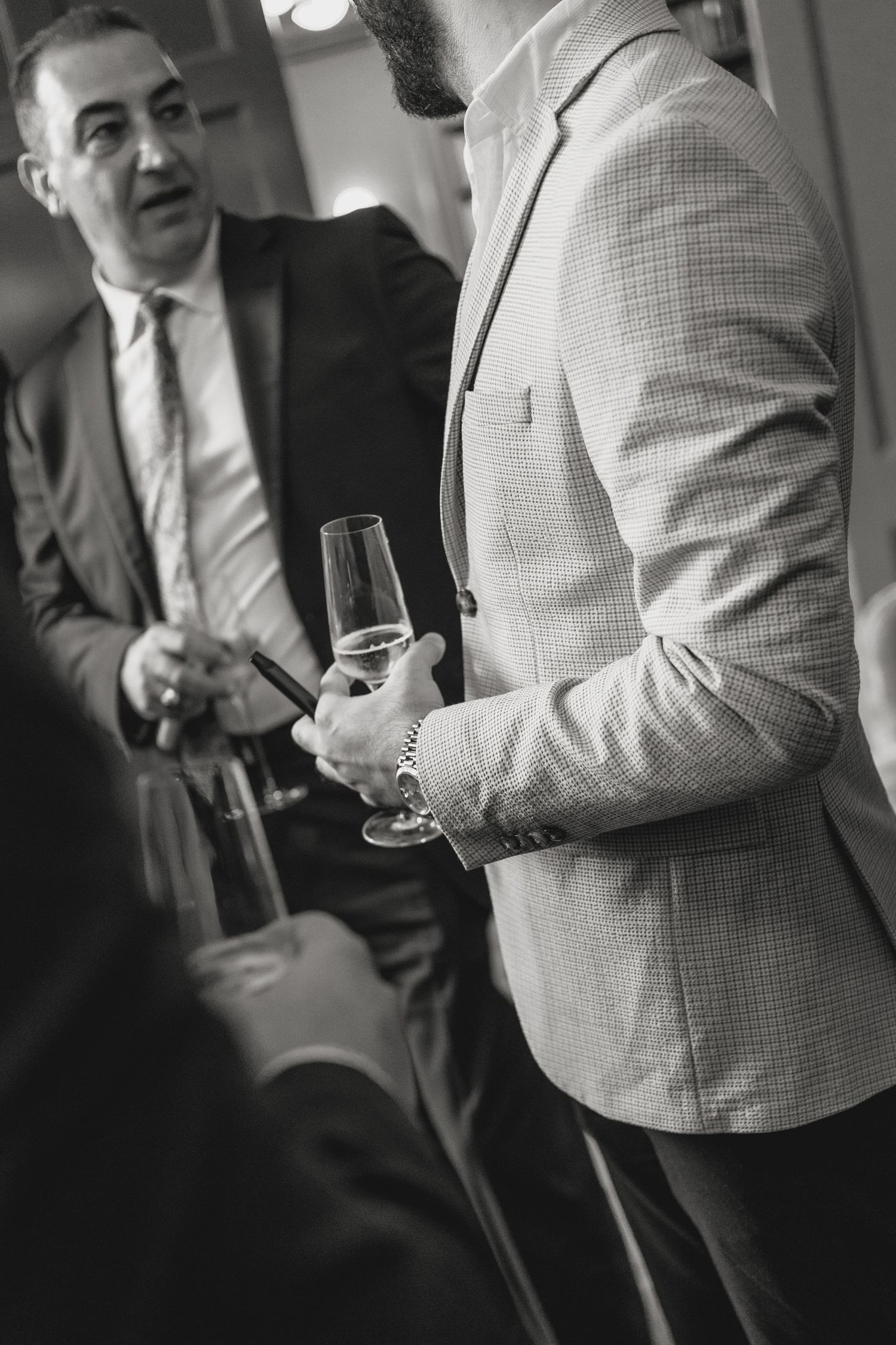 Black and white candid shots of people holding drinks at formal event.