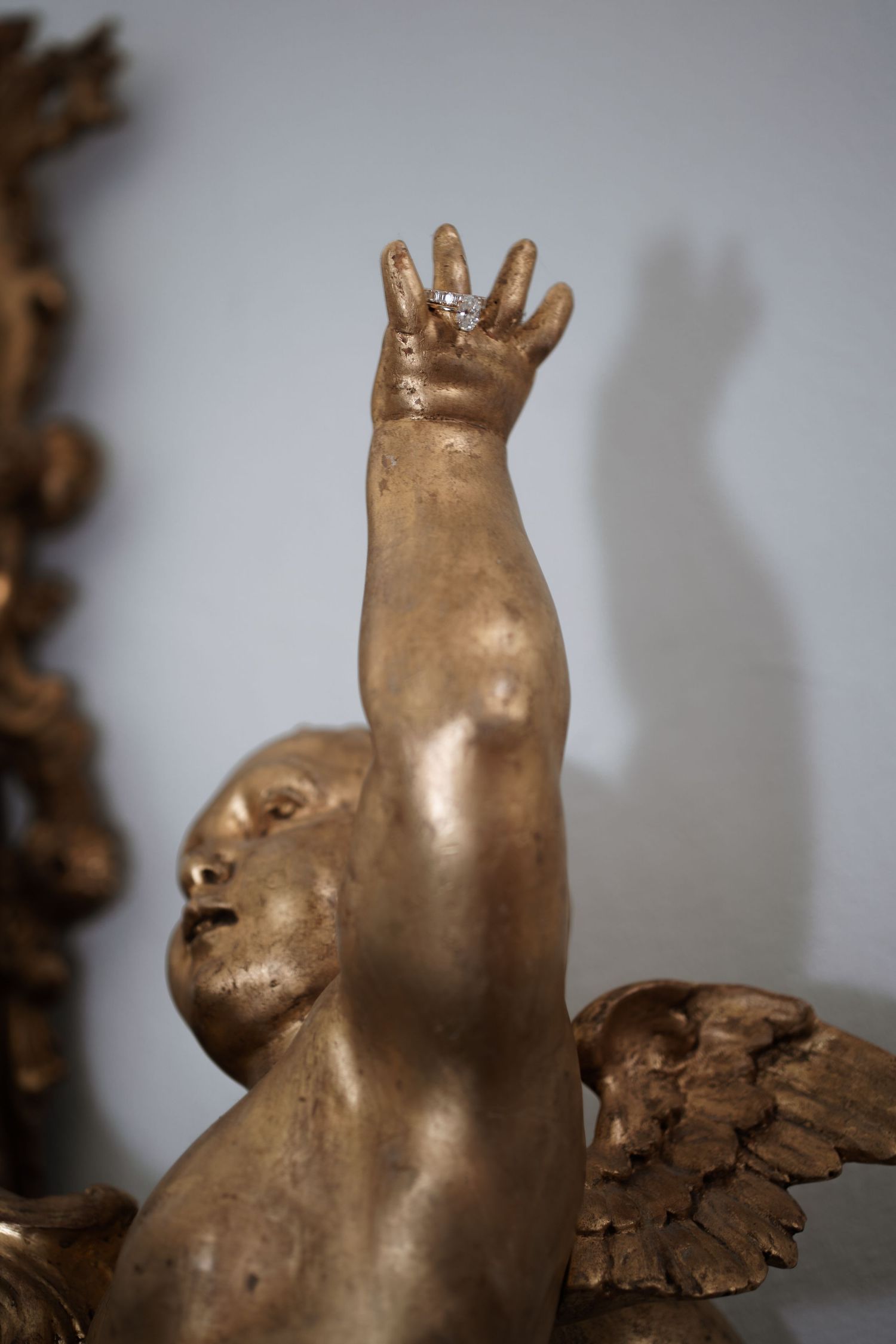Gold decorative sculpture of an animal figure against a gray background.